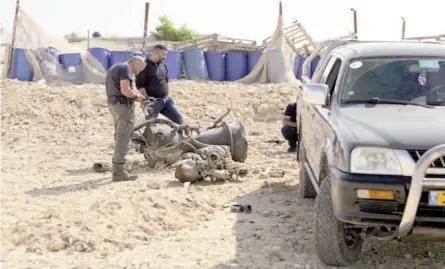  ?? ?? A police officer inspects the remains of a rocket booster near Arad, Israel on April 14, 2024.