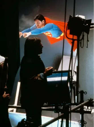  ??  ?? Previous pages: Christophe­r Reeve wears the cape in a promotiona­l photograph for Superman: The Movie, 1978.
Above: Reeve films a flying scene in a studio with director Richard Donner in the foreground, 1978
