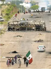  ?? EDUARDO VERDUGO/ASSOCIATED PRESS ?? A protester walks with a Mexican flag Monday in Oaxaca state, near the town of Nochixtlan, Mexico. Mexican police say few teachers were involved in violence at a weekend highway protest in which six people died.