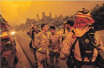  ?? NOAH BERGER THE ASSOCIATED PRESS ?? Firefighte­rs discuss plans while battling the Carr fire in Shasta, Calif., on Thursday.