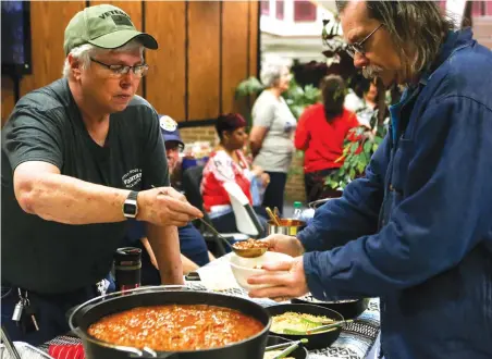  ?? Staff photo by Hunt Mercier ?? ■ Annette McRaven serves Charles Haskins some of her homemade chili Friday at the Texarkana Area Veterans Council Chili Cook-Off at Texarkana College in Texarkana, Texas.