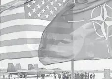  ?? PETRAS MALUKAS, AFP/GETTY IMAGES ?? The flags of the United States and NATO, which was created in 1949 and comprises 28 member countries.