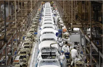 ?? NG HAN GUAN / AP ?? Employees work on a car assembly line at the Dongfeng Honda Automobile Co., Ltd factory in Wuhan in central China’s Hubei province on April 8. The United States, Japan and France are prodding their companies to rely less on China to make smartphone­s, drugs and other products.