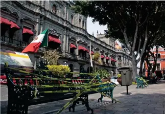  ??  ?? El ayuntamien­to de Puebla colocó cintas de precaución en algunas bancas del zócalo con la finalidad de disminuir la presencia de personas ante la emergencia sanitaria por Covid-19.