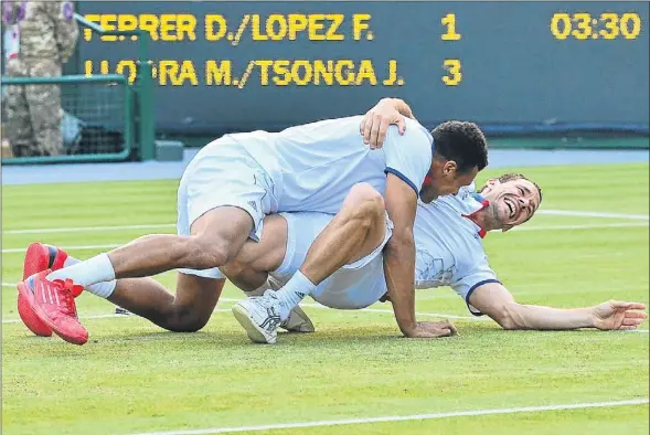  ?? LUIS ACOSTA / AFP ?? Michael Llodra y Jo-Wilfried Tsonga se abrazan en el suelo al conseguir la victoria ante la pareja española