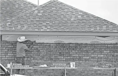  ?? CHRIS LANDSBERGE­R/THE OKLAHOMAN FILE ?? A man works on a new home by Home Creations in Norman’s Bellatona addition.