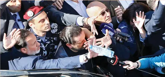  ??  ?? Bodyguards protect Lebanese PM Saad Hariri, center, from a water bottle thrown by demonstrat­ors in downtown Beirut, Lebanon, on Sunday. (AP)