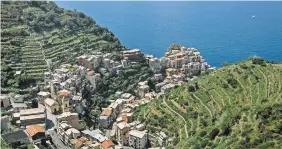  ?? GIANNI CIPRIANO FOR THE NEW YORK TIMESS ?? The terracing around Manarola, one of Italy’s Cinque Terre villages, keeps the land from sliding into the sea.