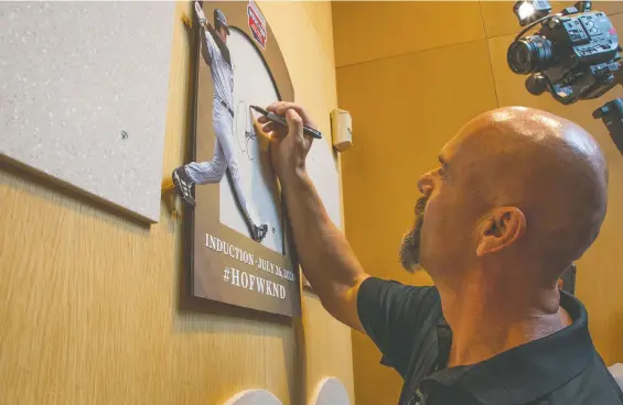  ?? MILO STEWART JR. ?? Larry Walker signs a plaque honouring his selection to the Baseball Hall of Fame in Cooperstow­n, N.Y., where the induction ceremony slated for 2020 was delayed a year.