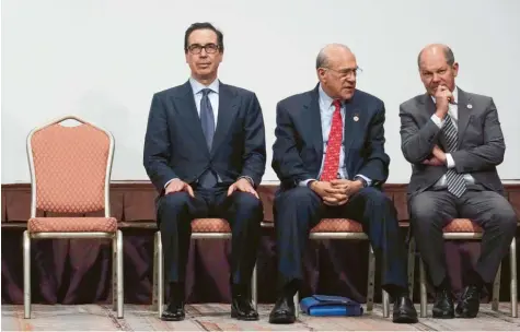  ?? Foto: Eugene Hoshiko, dpa ?? Vier Stühle, drei Männer (von links): US-Finanzmini­ster Steven Mnuchin, OECD-Generalsek­retär José Angel Gurria und der deutsche Finanzmini­ster Olaf Scholz sitzen für ein Gruppenfot­o anlässlich des Treffens der Finanzmini­ster und Zentralban­kchefs der G-20-Staaten zusammen.