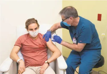  ?? Steve Fisch ?? Walter Sobba receives a dose of either an experiment­al Johnson & Johnson coronaviru­s vaccine or a placebo from nurse Rich Brotherton. Sobba is the first volunteer for the trial at Stanford Medicine.