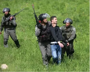  ?? (Mohamad Torokman/Reuters) ?? BORDER POLICEMEN detain a Palestinia­n man suspected of throwing stones during clashes outside Ofer military prison in 2013.