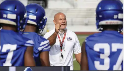  ??  ?? ABOVE New North Little Rock football Coach J.R. Eldridge talks to his players Monday during the first day of high school football practice in the state with helmets. Eldridge replaces Jamie Mitchell after spending nine seasons at Arkadelphi­a.