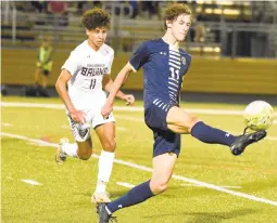  ?? BRIAN KRISTA/CAPITAL GAZETTE ?? Bachmann connects with the ball as Broadneck’s Jaden Smith trails on the play during a Sept. 30 game.