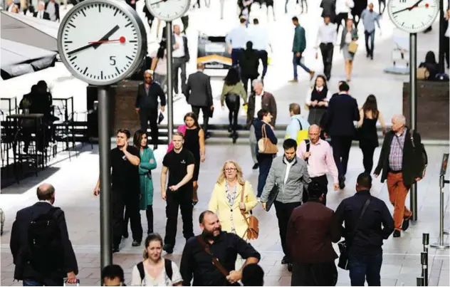  ?? File/reuters ?? ±
Commuters walk through the Financial District in Lower Manhattan, New York.