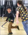  ??  ?? Kenzlie Leach (right) throws a ball and (left) Lucas Pitigliano, left, attempts to dodge a shark attack by Alxy Quillin during Winter Day Camp activity Thursday at the Heritage Center in Portervill­e.