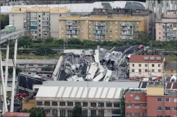  ??  ?? Cars are blocked on the Morandi highway bridge after a section of it collapsed, in Genoa, northern Italy on Tuesday. A large section of the bridge collapsed over an industrial area in the Italian city of Genova during a sudden and violent storm, leaving vehicles crushed in rubble below. AP PHOTO/ANTONIO CALANNI