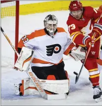  ?? JEFF MCINTOSH — THE CANADIAN PRESS VIA AP ?? Flyers goalie Samuel Ersson keeps watch as the Calgary Flames’ Tyler Toffoli tries to deflect the puck into the net during the first period Monday night.