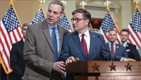  ?? PHOTOS BY J. SCOTT APPLEWHITE/AP ?? During a recent news conference, Speaker Mike Johnson, R-La. (right), defended his position, saying he is working “to turn an aircraft carrier” of how Washington deals with appropriat­ion funding, which “takes a long time.” Rep. Scott Perry, R-Pa., who previously chaired the Freedom Caucus, then put his arm around Johnson and defended him.