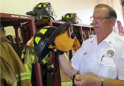  ?? Staff photo by Neil Abeles ?? ■ The helmets worn by firefighte­rs cover so well that not an area of skin is exposed, said Atlanta Assistant Fire Chief Ricky Draper.