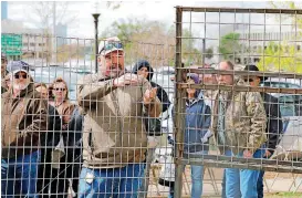  ?? [PHOTOS BY STEVE GOOCH, THE OKLAHOMAN] ?? Assistant State Director of the USDA Scott Alls demonstrat­es a feral hog trap Thursday at the state Capitol.