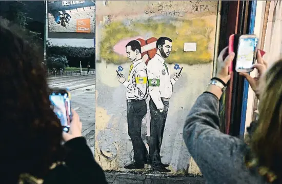  ?? MIGUEL MEDINA / AFP ?? Di Maio y Salvini, hombres fuertes del Gobierno italiano, en el mural La guerra de las redes sociales, del artista TvBoy, en Milán