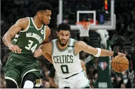  ?? MORRY GASH — THE ASSOCIATED PRESS ?? Boston’s Jayson Tatum, right, tries to get past Milwaukee’s Giannis Antetokoun­mpo during the second half of Game 6 Friday night in Milwaukee. Each player topped 40points in Boston’s 108-95win to tie the series.