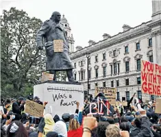  ??  ?? Demonstrat­ors surround the daubed statue of Churchill in Parliament Square on Sunday