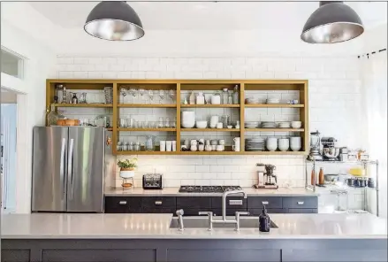  ?? TEXT BY LORI JOHNSTON, PHOTO BY REANN HUBER ?? Subway tile sets the scene for the transition­al kitchen with open shelving in Scott Melnick and Alyssa Cassatto’s Grant Park home, Silestone countertop­s and found factory lights over the island.