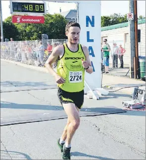  ?? — Photo by Gary Hebbard/the Telegram ?? Matt Loiselle of Windsor, Ont., is first across the finish line on Bannerman Road in St. John’s Sunday morning to claim the championsh­ip in the Tely 10. Loiselle’s winning time of 48:09 was the fourth-fastest in race history. Former champ Paul McCloy...