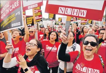  ?? Christina House Los Angeles Times ?? LICENSED MARRIAGE and family therapists Leslie Fuentes-Nguyen, left, and Monica Garcia gather at the Kaiser Permanente facility on Sunset Boulevard for a strike by the National Union of Healthcare Workers.