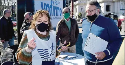  ??  ?? DOMINGO DE FERIA. María del Carmen González y Fernando López, dos militantes del Frente Amplio en plena recolecció­n de firmas.