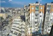  ?? HUSSEIN MALLA/AP ?? Cranes remove debris next to destroyed buildings Friday in Antakya, southeaste­rn Turkey. Rescuers pulled several earthquake survivors from the shattered remnants of buildings Friday.