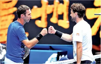  ?? - AFP photo ?? Thiem (right) fist bumps with Mikhail Kukushkin after winning the men’s singles match on day one.