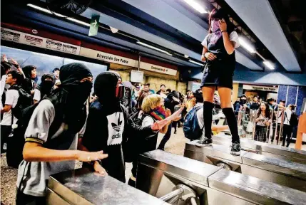  ?? AFP ?? ►SANTIAGO.
Estudiante­s en una manifestac­ión de rechazo al Gobierno en una estación del metro.