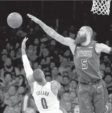  ?? Photograph­s by Luis Sinco Los Angeles Times ?? LAKERS CENTER Tyson Chandler blocks a shot by Trail Blazers guard Damian Lillard. Chandler had four points and six rebounds in 21 minutes as the Lakers improved to 4-0 since Chandler joined the team last week.