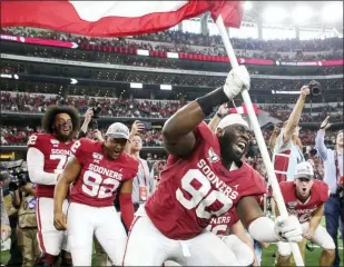  ?? IAN MAULE - TULSA WORLD VIA AP ?? Oklahoma defensive lineman Neville Gallimore (90) plants a University of Oklahoma flag after the Sooners 30-23 overtime win over Baylor in an NCAA college football game for the Big 12 Conference championsh­ip, Saturday, in Arlington, Texas.