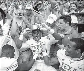  ?? AP/NICK WAGNER ?? Texas defensive back Josh Thompson (29) celebrates with fans while wearing the Golden Hat following No. 19 Texas’ 48-45 victory over No. 7 Oklahoma at the Cotton Bowl in Dallas on Saturday.