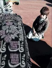  ?? AP ?? An Afghan boy kneels at the coffin of a relative Wednesday in Ghor province. The 26 civilians were seized Tuesday.