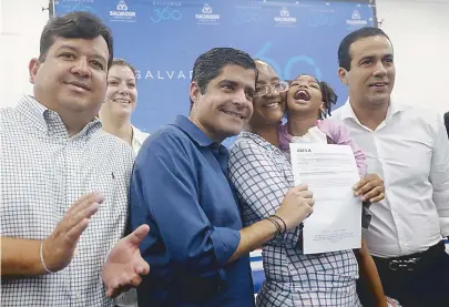  ??  ?? Prefeito entrega escritura à dona de casa Cleisivald­a, que leva no colo a filha Evellyn, que tem microcefal­ia