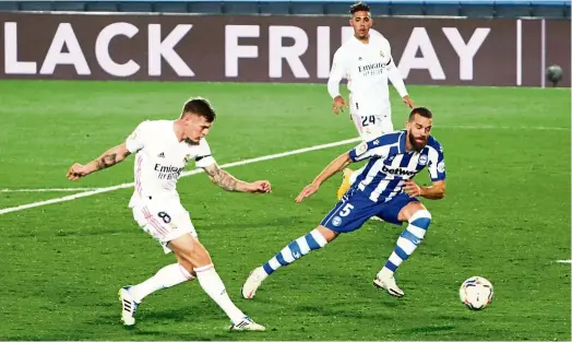  ?? — Reuters ?? Off target: Real Madrid’s Toni Kroos (left) passing the ball as Alaves’ Victor Laguardia looks on during the La Liga match in Madrid.