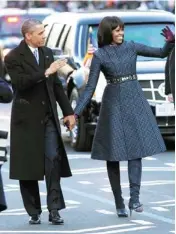  ?? AP PHOTOS ?? President Barack Obama and first lady Michelle Obama walk Monday in the inaugural parade on Capitol Hill in Washington.