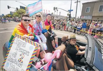  ?? Howard Lipin San Diego Union-Tribune ?? SAM MOEHLIG, left, his mother, Kathie, and his boyfriend, Augustus Lawson, at San Diego’s Pride parade.