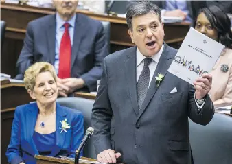  ?? ERNEST DOROSZUK ?? Premier Kathleen Wynne looks on as Finance Minister Charles Sousa delivers the provincial budget on Wednesday, which critics say is clearly designed to buy votes in June’s provincial election.