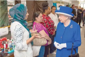  ?? — AFP ?? Queen Elizabeth II meets members of the community affected by the Grenfell Tower disaster during a visit to the Westway Sports Centre which is providing temporary shelter for those who have been made homeless, in west London on Friday.