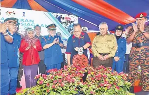  ??  ?? BEJADI: Shahidan (tengah) nekan suis perengkagu­na kelai bejadika Bulan Kesiapsiag­aan Nasional 2017’ ba Kuching Waterfront, kemari. Bela dipeda Uggah (tiga kiba) enggau Nor Hisham (kanan).