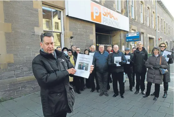  ?? Picture: Dougie Nicolson. ?? Mr Fraser and disgruntle­d fine recipients outside Smark Parking’s Kinnoull Street site in Perth.