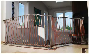  ??  ?? This inventive copper and stainless steel railing has the effect of a sound wave moving through a set of strings while also adhering to building code restrictio­ns. Photograph­er    Patrick Wey