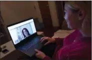  ?? MARK LENNIHAN — THE ASSOCIATED PRESS ?? Caitlin Powers sits in the living room of her Brooklyn apartment in New York last month and has a telemedici­ne video conference with Dr. Deborah Mulligan.