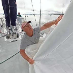  ?? PETER PEREIRA/AP ?? Bob Warren, removing the headsail, and Fran Grenon prepare a sailboat Tuesday in Mattapoise­tt, Mass., for the possible landfall of Hurricane Lee.